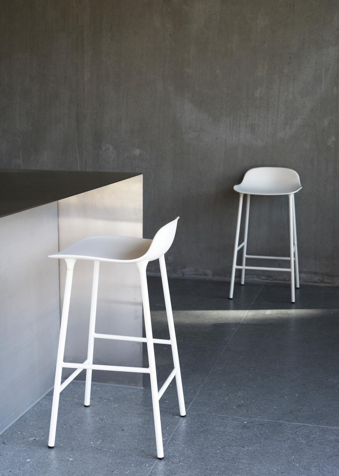 Hocker bildet warmes Grau mit einer goldenen Basis