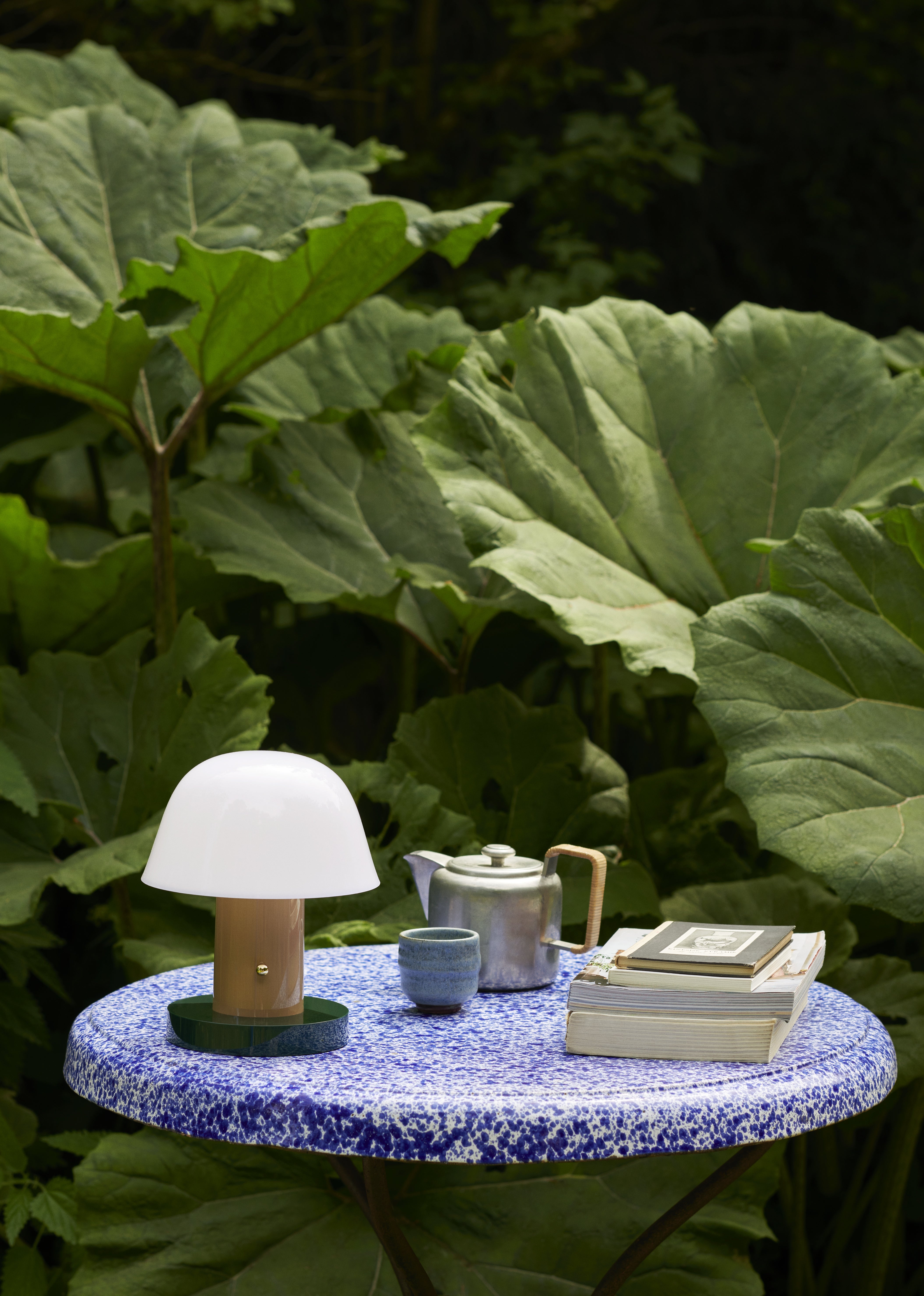 Tragbare Lampe SETAGO JH27 mit cremefarbenem Schirm und beige-grünem Fuß.