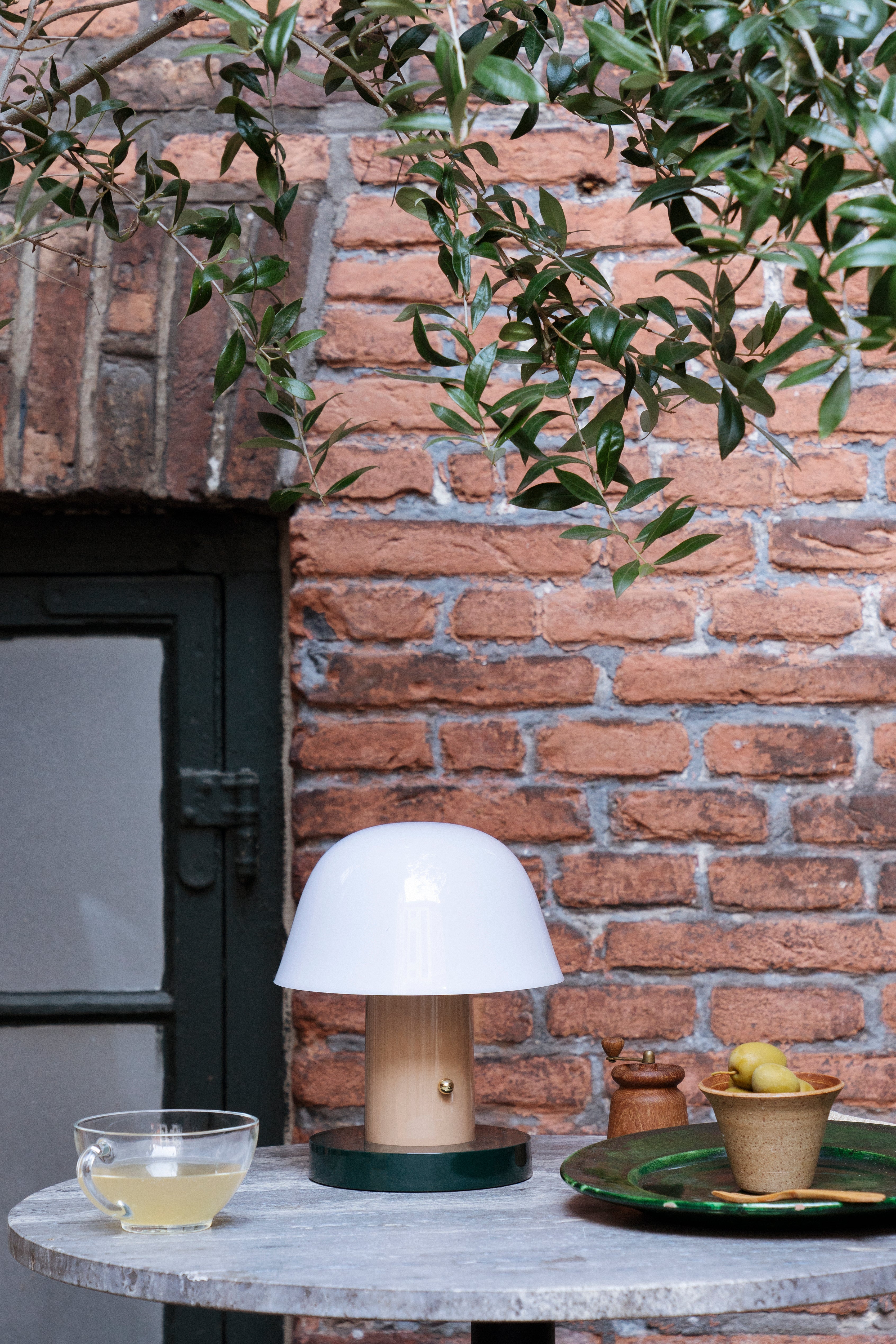 Tragbare Lampe SETAGO JH27 mit cremefarbenem Schirm und beige-grünem Fuß.