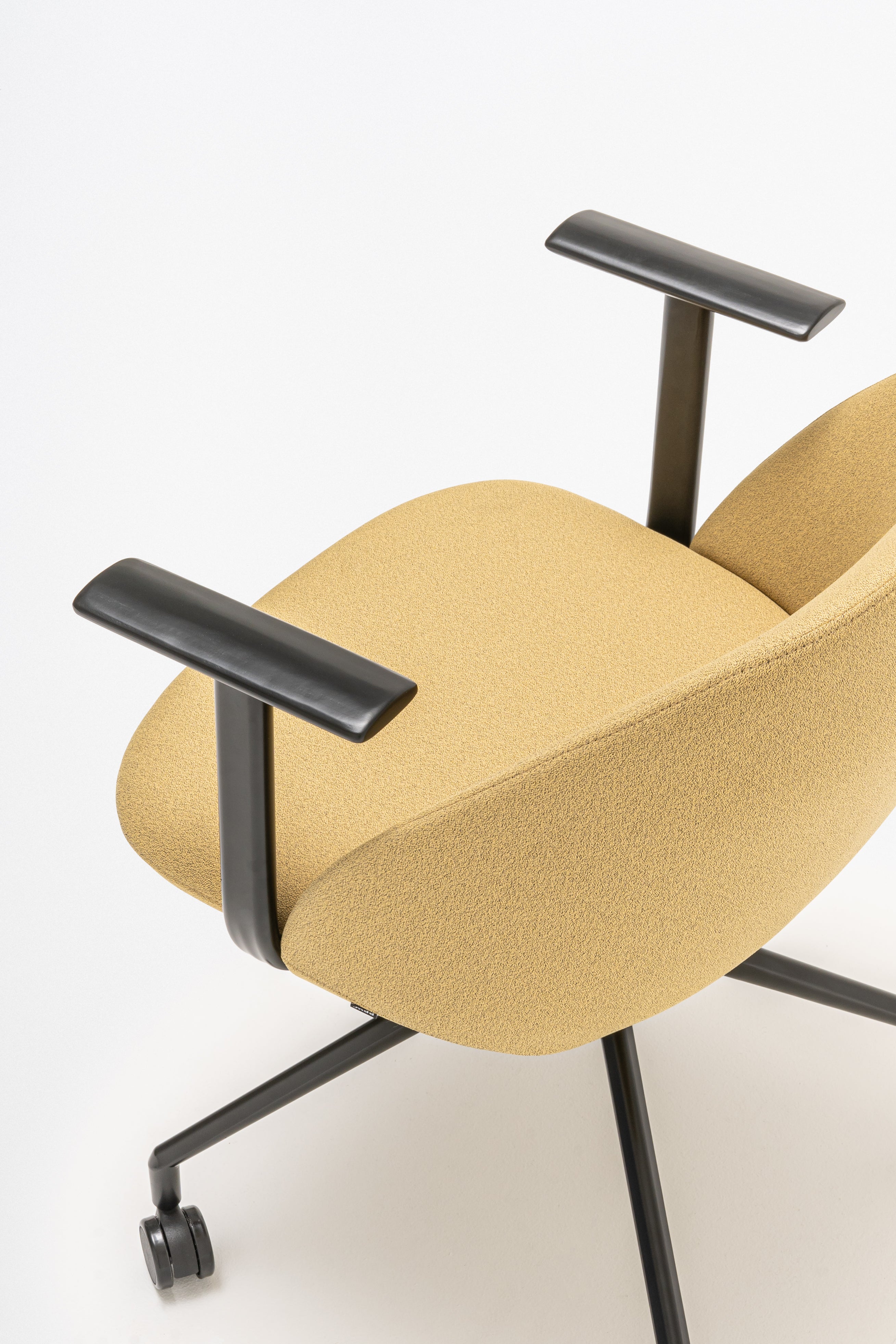 Rotable armchair with low backrest metal parallel base with wheels to a soft surface