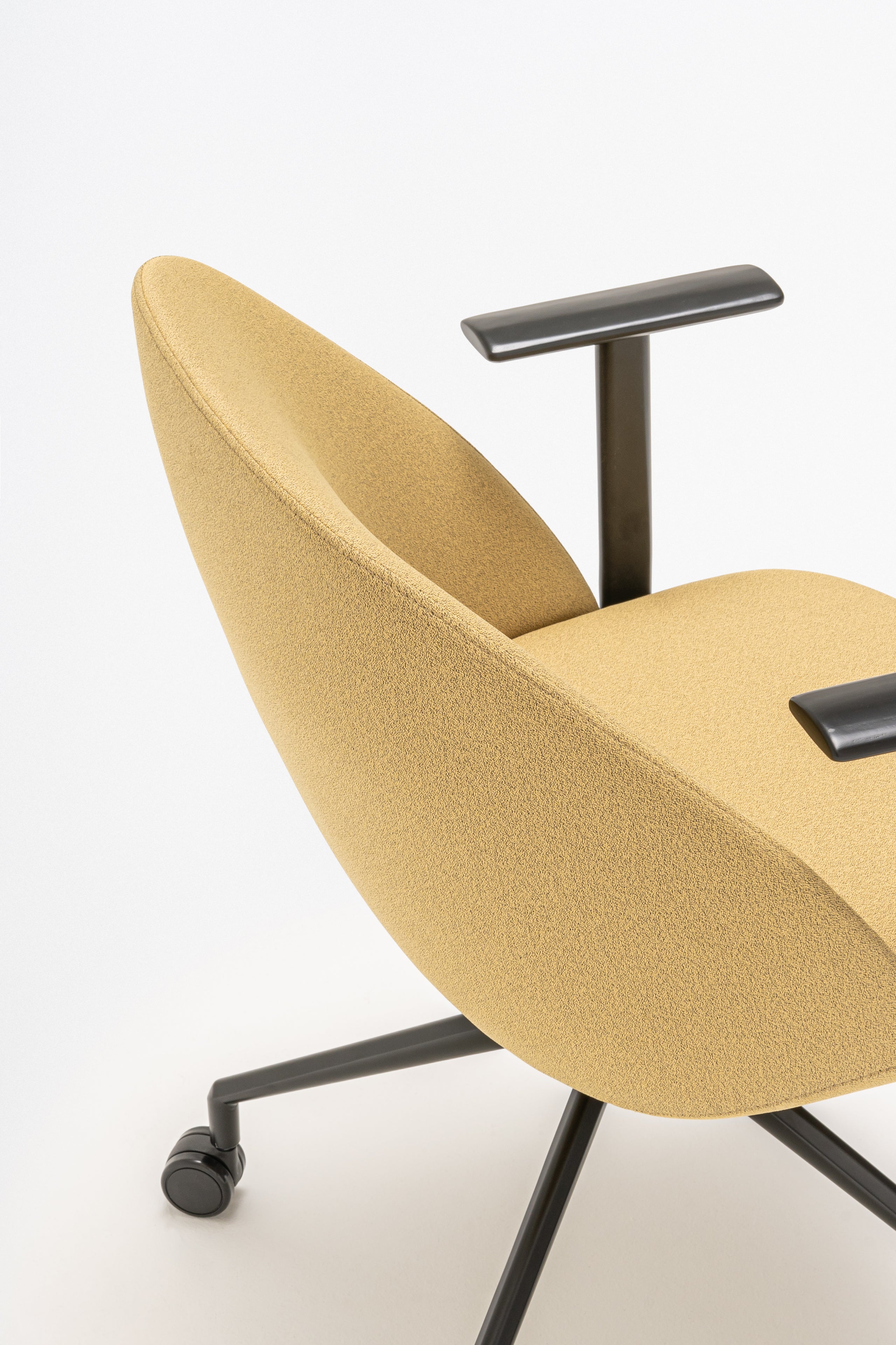 Rotable armchair with low backrest metal parallel base with wheels to a soft surface