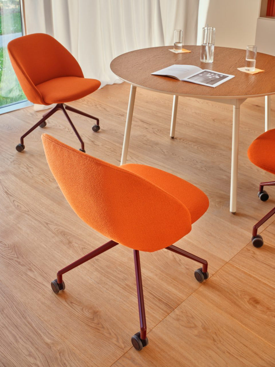 Rotable armchair with low backrest metal parallel base with wheels to a soft surface