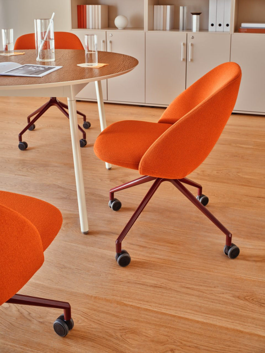 Rotable armchair with low backrest metal parallel base with wheels to a soft surface
