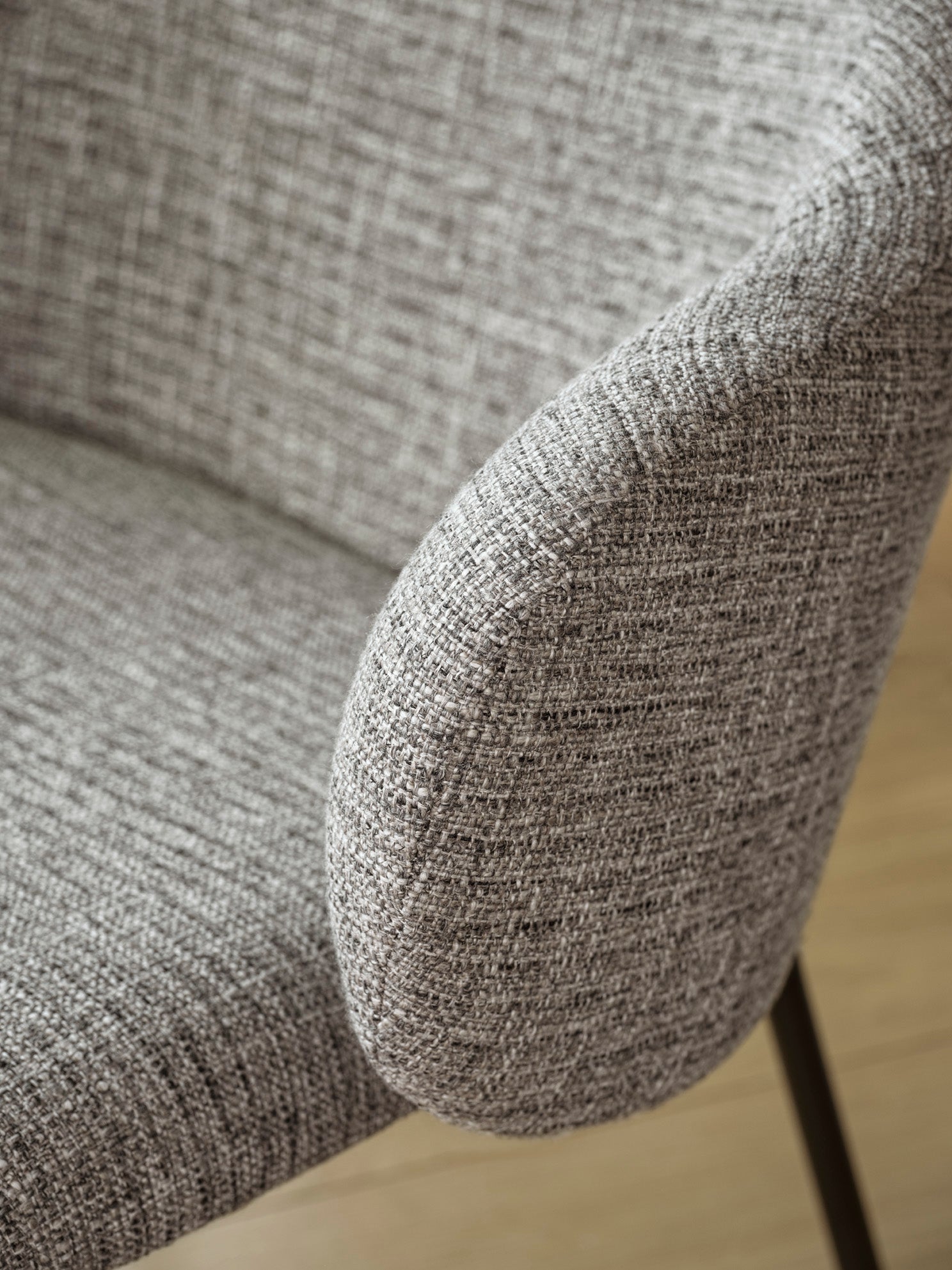 HOLLY upholstered armchair with a black base