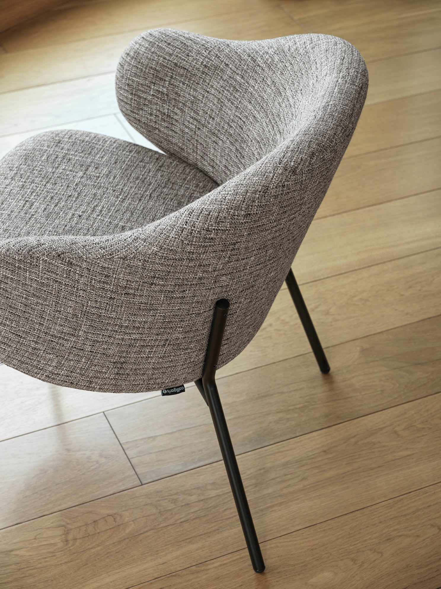 HOLLY upholstered armchair with a black base